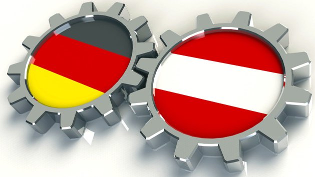 Flaggen von Deutschland und Österreich in Zahnrädern