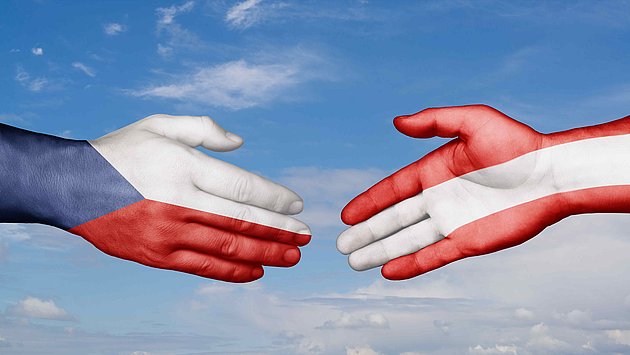 Ruce s českou a rakouskou vlajkou